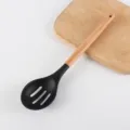 Silicone slotted spoon with wooden handle, black kitchen cooking utensil and tool for home use. - Slotted Spoon