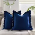 Vista dettagliata della federa per cuscino in velluto blu scuro con bordi a onda eleganti. - Bordo smerlato blu navy