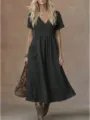 Casual black v-neck short sleeve pocket midi dress detailed view highlighting relaxed fit and side buttons. - S / Dresses / Black