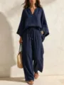 Detail view of a solid navy blue linen two piece set featuring a V neck loose top and pants. - Navy Blue
