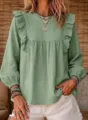 Close-up view of the sage green boho ruffle blouse featuring bubble sleeves and delicate details. - Light Green