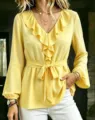 Detailed view of the yellow V-neck long sleeve blouse featuring stunning ruffles and waist tie. - Yellow