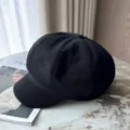 Detailweergave van een klassieke zwarte krantenbezorgerspet met textuur op tafel - Zwart