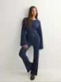 Gedetailleerd overzicht van de elegante marineblauwe top met lange mouwen en broek. - Marineblauw