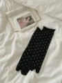 Detalle de calcetines negros de dos dedos con lunares blancos en una sábana blanca. - Talla única / Negro