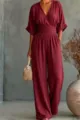 Detailed view of the elegant burgundy v-neck jumpsuit featuring cinched waist and wide legs. - Burgundy