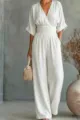 Close-up detail of a white V-neck short sleeve jumpsuit with banded waist and wide leg cut. - S / White