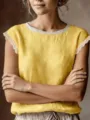 Close-up detail of women's yellow sleeveless top with elegant white lace collar and sleeve trim. - S / Tops / Yellow