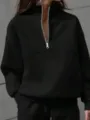Close-up detail showcasing the sleek black quarter-zip sweatshirt collar and silver zipper. - S / Tops / Black