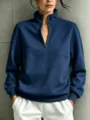 Close-up detail of a dark blue quarter-zip stand collar sweatshirt with ribbed hem. - S / Tops / Navy Blue