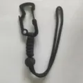 Detailed view of the black multi-functional paracord carabiner and adjustable wrist strap. - Black
