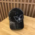 Nahaufnahme der schwarzen Netz-Baseballkappe mit Pailletten, Spitze und Strass-Schmetterling. - Verstellbar / Schwarz
