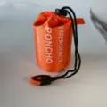 Orange emergency poncho storage bag, waterproof fabric with black drawstring and whistle. - Orange Raincoat Bag with Orange and Black Whistle