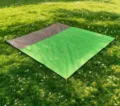 Detail shot of waterproof green and grey camping picnic mat spread on lush grass. - 200*210cm / Main Green + Gray