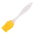 Detailed view of silicone basting brush with bright yellow head and white handle. - Yellow