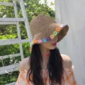 Primo piano del cappello di paglia estivo con dettagli floreali colorati lavorati all'uncinetto. - M(56-58cm) / Marrone