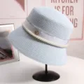 Dettaglio dell'elegante cappello da pescatore in paglia azzurra con perle e logo in metallo. - M(56-58CM) Regolabile / Celeste