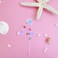 Detailed view of the pink acrylic number four cake topper featuring cute ocean sea life designs. - 4 / L