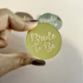 Primo piano di un disco rotondo in acrilico bride to be con dettagliata incisione al laser. - Oro