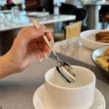 Stainless steel spoon detail, ergonomic square handle, elegant tableware close-up view. - Tea Spoon