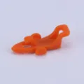 Orange plastic fishing rod hook keeper lure holder accessory for fishing gear detail shot. - Orange