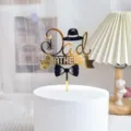 Detailed view of gold and black acrylic Dad cake topper with hat for Father's Day. - Father