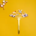 Detalle de decoración de pastel en abanico dorado estilo chino con grulla y olas elegantes. - Estilo Forma de Abanico