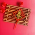 Details of the Chinese New Year acrylic cake topper featuring a festive red spring character design. - Spring Character (Gold) / Gold