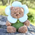 Süßer brauner Teddybär Plüschtier mit hellblauem Blumenkragen und grünem Körper Design. - Blumenbär Blau / Blau