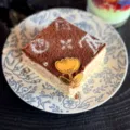 Quadratischer Tiramisu-Kuchen mit Kakaopulver-Muster und goldenem Acryl-Blumen-Deko. - Markierte Blume 2 / 5er-Pack