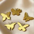 Close-up detail of golden acrylic butterfly cake toppers on smooth fabric background. - Acrylic Butterfly 5-Piece Set (Width Approx 4CM)