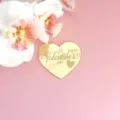Gros plan d'un topper de gâteau cœur en acrylique miroir doré gravé Saint Valentin. - Joyeuse Saint-Valentin cœur doré