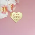 Gros plan détaillé d'un joli cake topper miroir en cœur doré brillant avec le texte love - Lettres LOVE Or