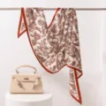 Elegante pañuelo de seda y lana con estampado paisley y borde rojo para mujer, ideal para otoño. - Encaje Naranja Paisley