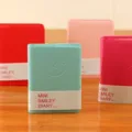 Close-up detail of mini smiley diary notebooks with colorful covers and cute embossed face. - Default