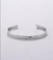 Minimalist stainless steel open cuff bracelet detail view showing hammered texture. - Platinum