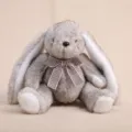 Mignon lapin en peluche aux longues oreilles assis avec nœud papillon, poupée douce cadeau. - Environ 23 cm/110 g / Lapin assis en fausse fourrure avec nœud papillon - Gris