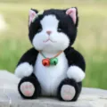 Simpatico gatto nero e bianco di peluche seduto con collana a campana, morbido regalo. - Gatto seduto con campanello - Nero