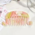 Close-up view of a French acetate hair comb featuring pearlescent pink and yellow marbled gradient design. - Pink/Yellow