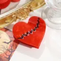 Gros plan détail de la pince à cheveux cœur en acétate rouge avec motif de rythme cardiaque. - Cœur