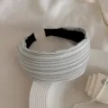 Detail shot of the black and white striped wide fabric headband, elegant tabletop accessory display. - Gray White Stripe Headband
