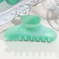 Detailed view of the green translucent acetate hair claw clip with gold text, elegant. - Medium Crescent - Emerald Green Sparkle