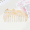 Detail shot of cute cat shaped acetate hair comb with tortoishell texture and golden details. - Creamy Yellow