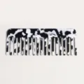 Black and white acetate wide-tooth comb close-up showing smooth marbled texture surface. - Black and White