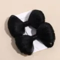 Vue détaillée de la pince à cheveux synthétique noire en nœud avec une texture bien duelle. - Barrettes à ressort pour perruque noires (paire)
