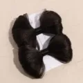 Gros plan de pinces à cheveux nœud marron foncé sur carte montrant la texture synthétique. - Barrettes à ressort pour perruque marron (paire)
