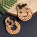 Close-up detail of fashion geometric tortoise shell and natural woven rattan drop earrings. - Leopard Coffee