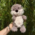 Primo piano di simpatico peluche di lontra, tessuto morbido e soffice, dettagli del viso, esterno. - 28cm / Lontra Grigia