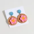 Chic woven rattan earrings featuring blue beads and pink floral charms on a display card. - Plumeria Rose Red