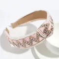 Large serre-tête tressé rose avec motif géométrique fil doré et perles délicates. - Rose